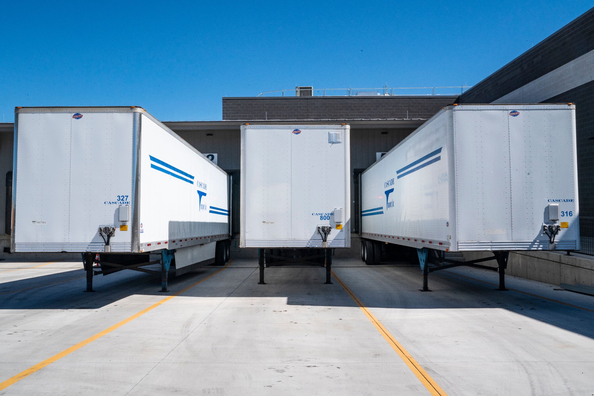 Spacious warehouse interior with loading doors and blue-toned lighting