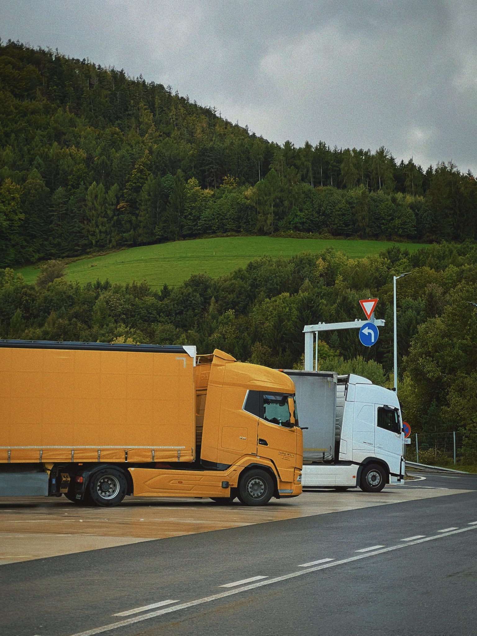 Orange and white trucks on a motorway interchange